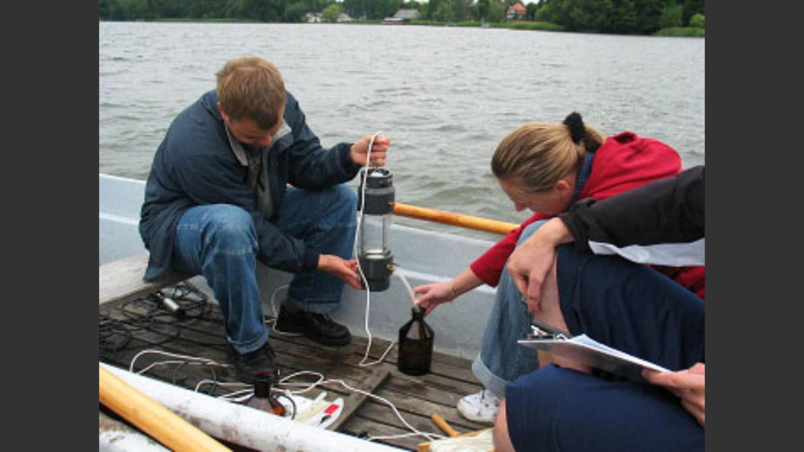 Mitarbeitende des Studienprojekts sitzen in einem Boot auf dem See und fhren eine Wasseranalyse durch