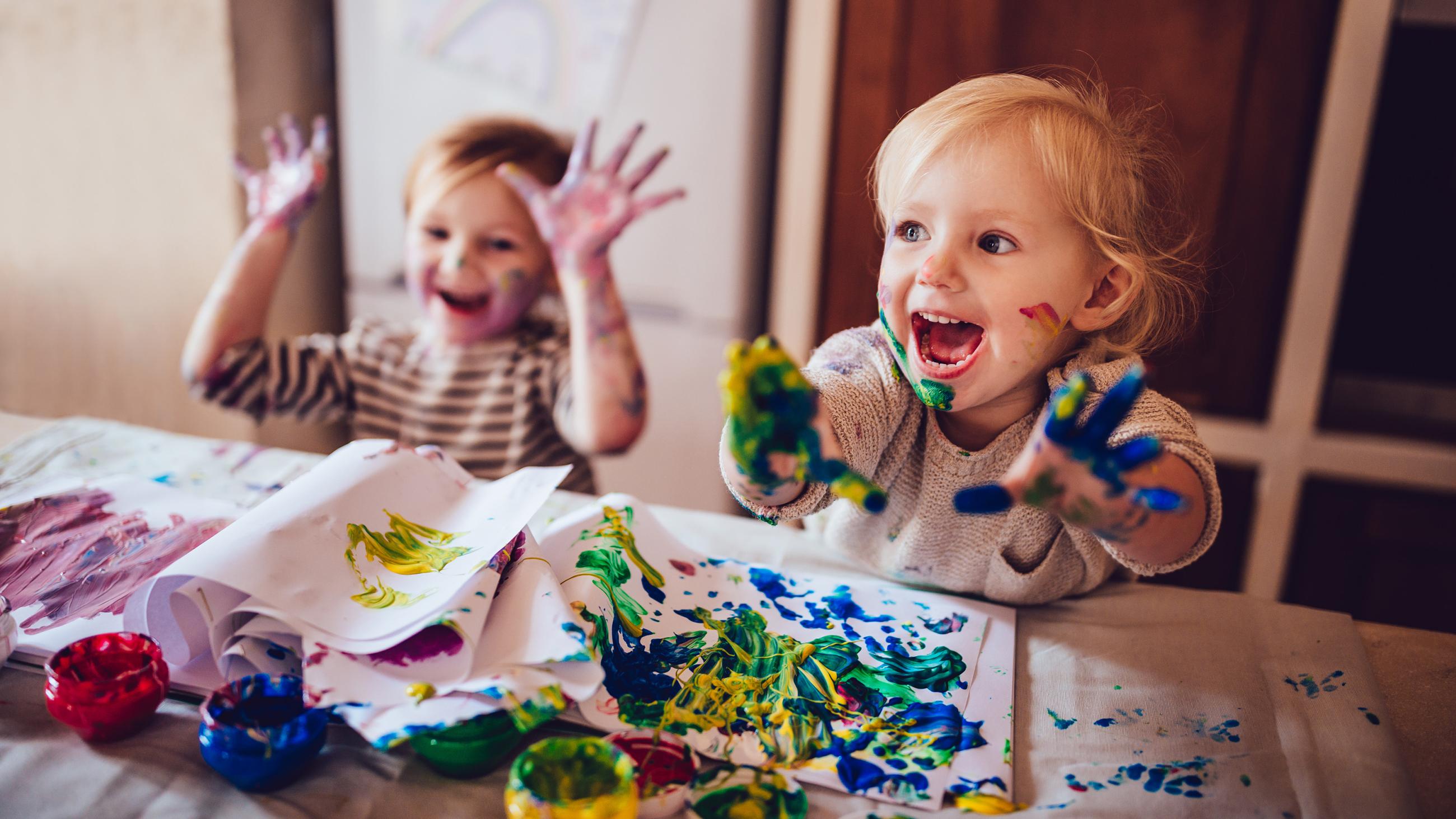 Zwei fr?hliche Kinder beim Malen mit Fingerfarben